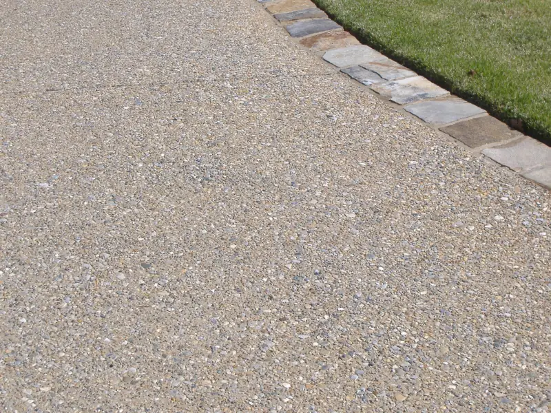 Exposed-aggregate concrete driveway with a stone-banded border