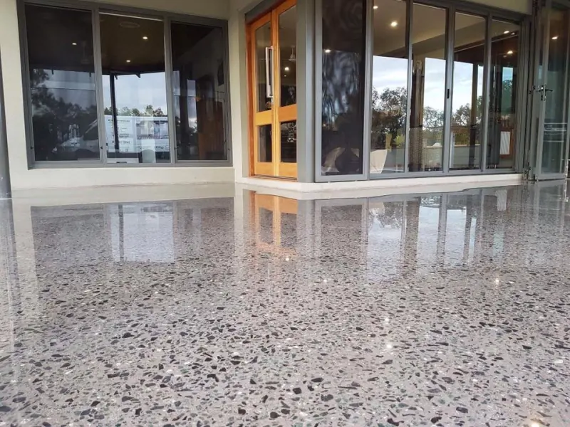 High-gloss polished concrete floor with exposed aggregate reflecting the room