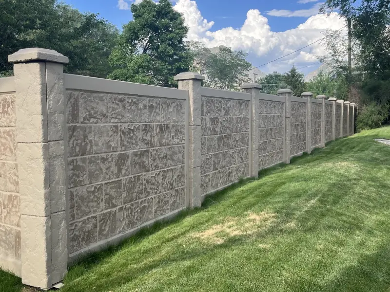 Precast concrete fence with stone-textured panels and slotted posts