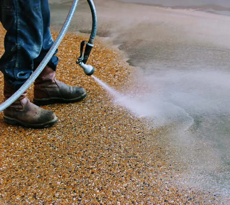 Washing off the surface to reveal an exposed-aggregate concrete finish