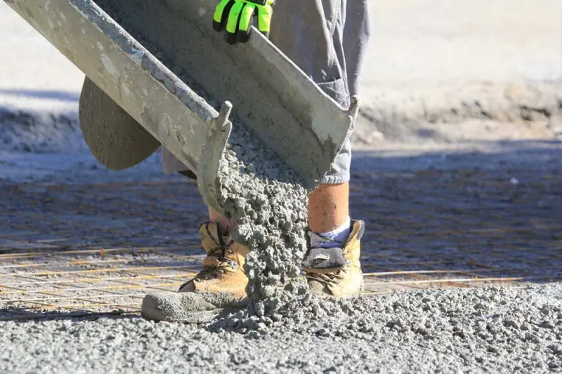 Concrete pouring from the truck chute onto mesh-reinforced base